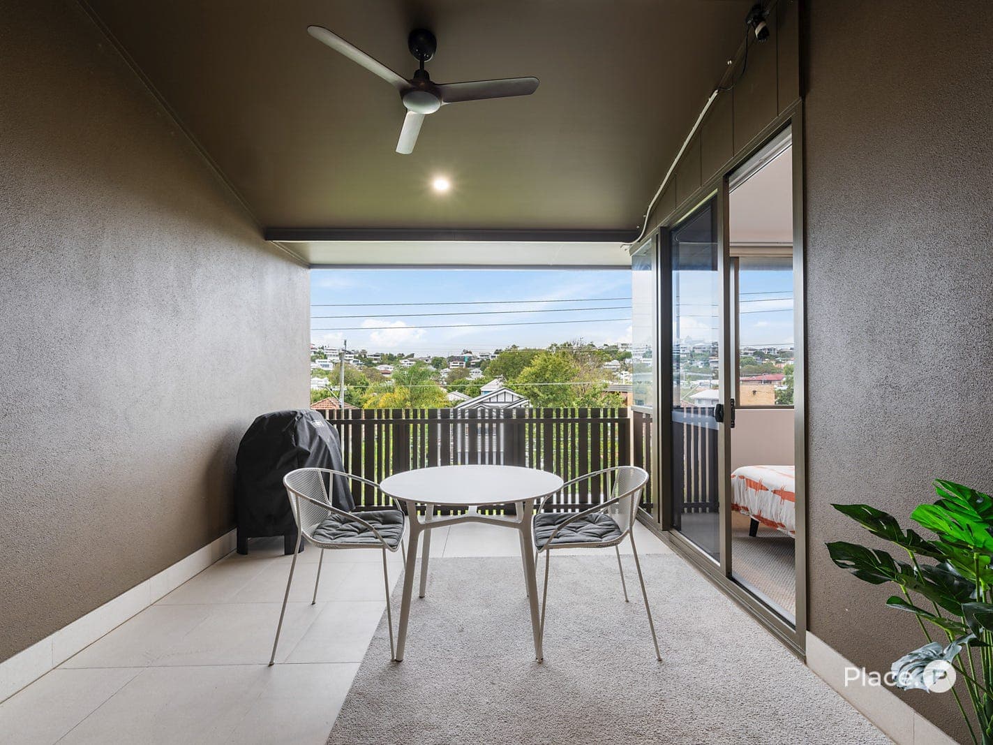 Covered entertaining balcony with ceiling fan and suburban vistas