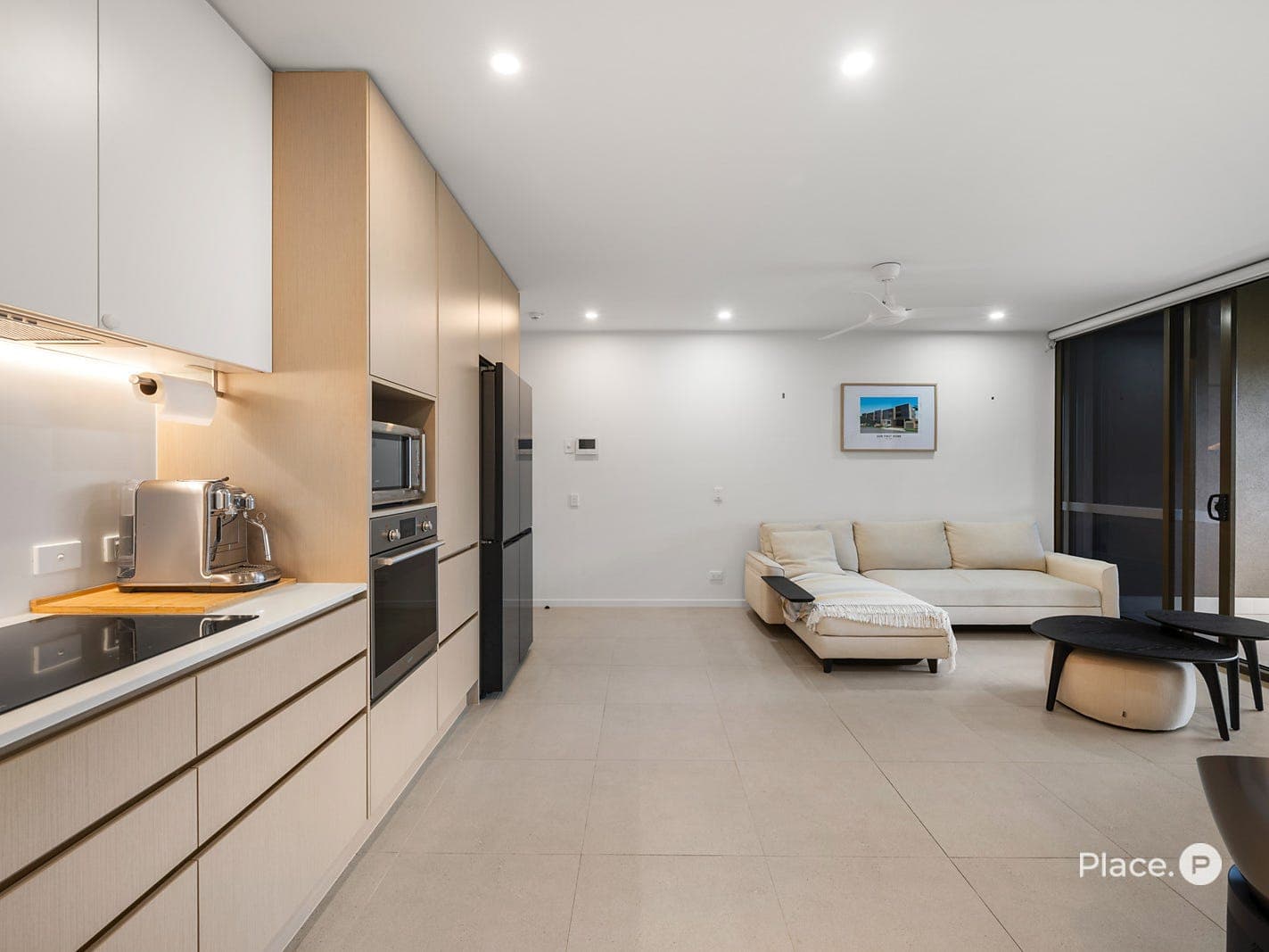 Kitchen and living looking towards the entry, with induction cooktop and oven