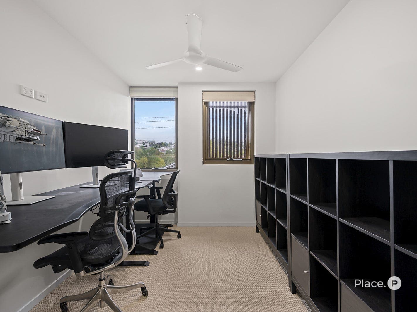 Second bedroom with built-in storage, ceiling fan and leafy outlook
